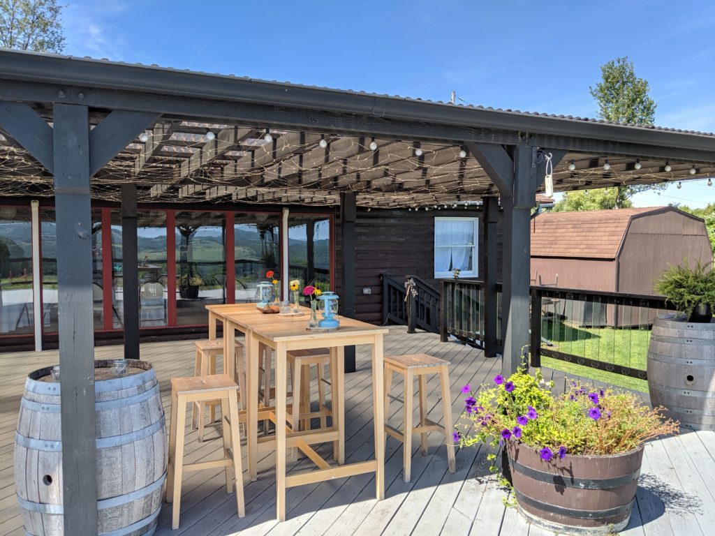 Cozy outdoor seating area at Castel Grish Winery with string lights and wooden tables