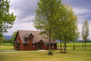 Tasting room with trees in front and green grass