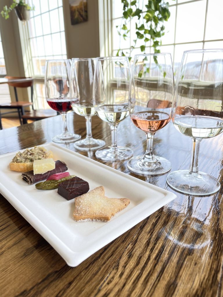 5 glasses of wine and a plate of small bites to pair with it