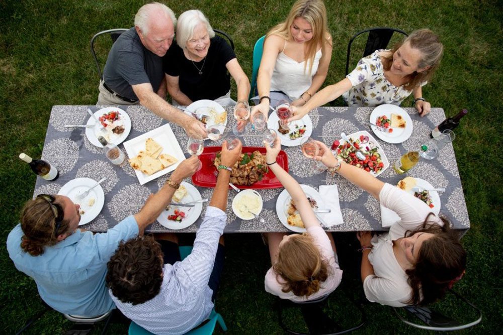 People sitting around a table with food and wine