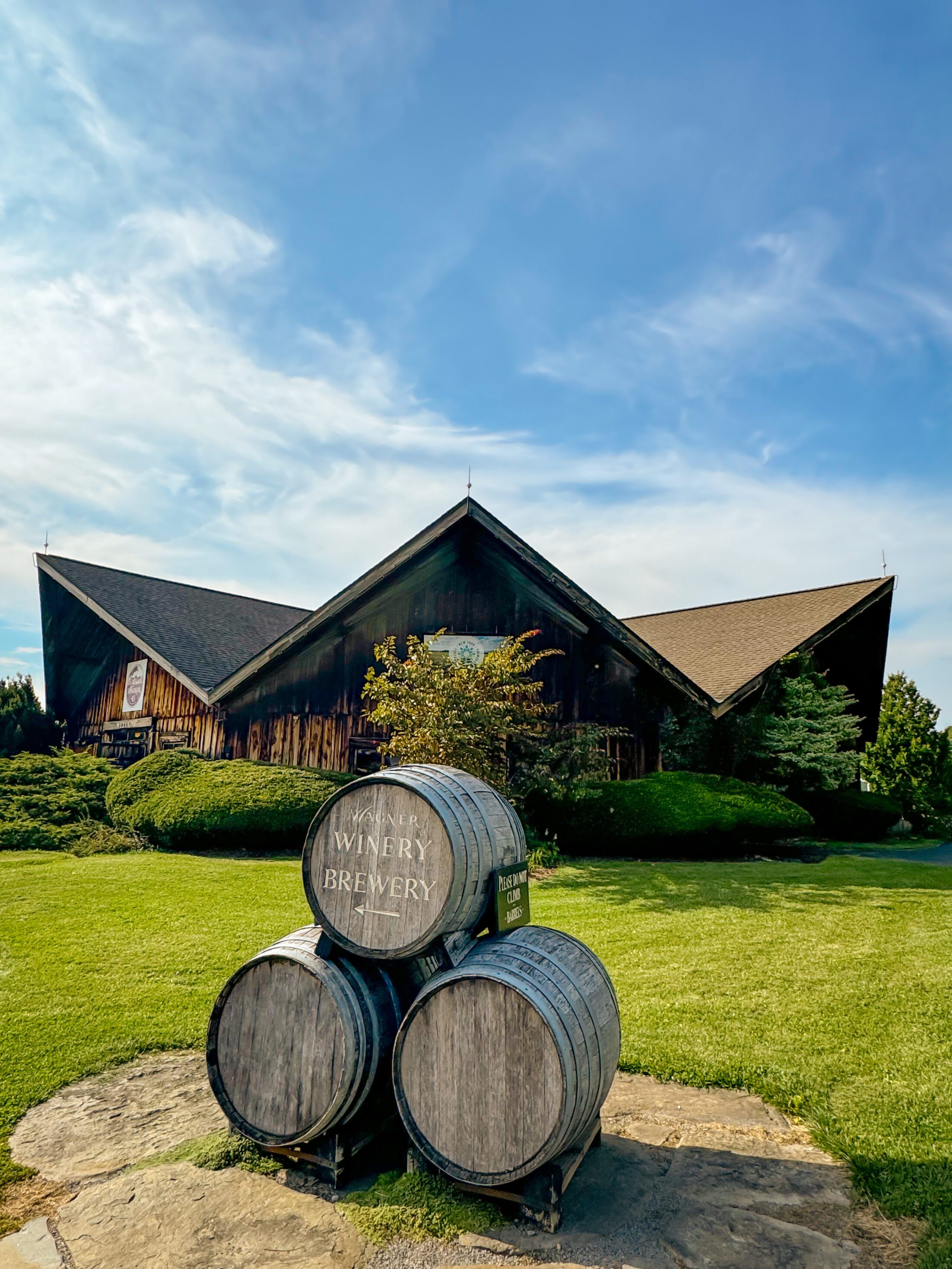 Wagner Vineyards building with 3 barrels in front of it.