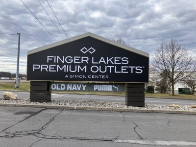 Black sign with white writing: Finger Lakes Premium Outlets