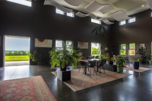Anthony Road Wine Company Tasting Room interior with tables, chairs, beautiful rugs, and a view of the lake.